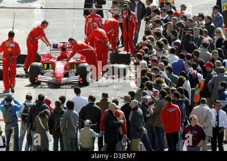 (Dpa) - Zuschauer umgeben die Mechanik arbeitet an einem Ferrari Rennwagen in der Formel-1-Rennstrecke in Imola, Italien, Freitag, 22. April 2005. Der Grand Prix von San Marino wird hier Sonntag, 24. April 2005 gestartet. Stockfoto