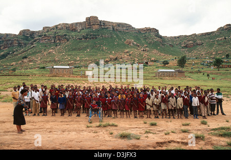 Schulkinder, die außerhalb einer ländlichen Schule auftreten, um Gäste zu begrüßen, Matsieng. Lesotho Stockfoto