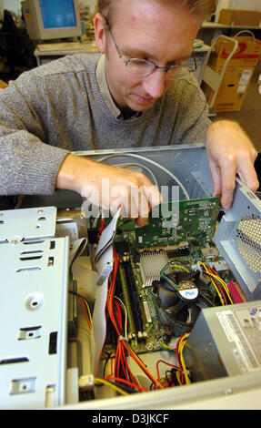 (Dpa) - ein Techniker installiert eine Grafikkarte in einem Computer AGP-Steckplatz in Hamburg, Deutschland, 28. Februar 2005. Stockfoto