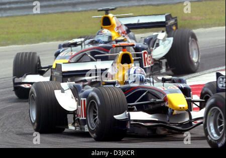 (Dpa) - britische Formel1-Fahrer David Coulthard (vorne) und seinen österreichischen Teamkollegen Christian Klien von Red Bull Racing in Aktion während der Grand Prix von Malaysia in Sepang, in der Nähe von Kuala Lumpur, Malaysia, 20. März 2005. Coulthard kam im 6. und 8. Klien. Stockfoto