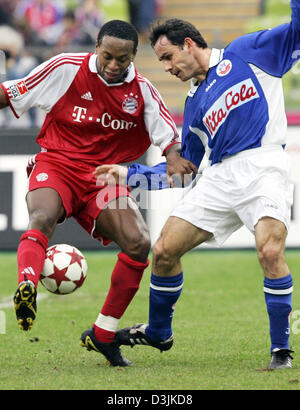 (Dpa) - Bayern Ze Roberto (L) kämpft für den Ball mit Rostocks Michael Hartmann während des Spiels zwischen FC Bayern München und FC Hansa Rostock in München, 19. März 2005. Stockfoto