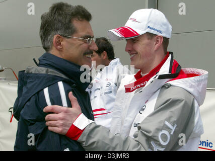 (Dpa) - deutsche BMW Motorsport Direktor Mario Theissen (L) und Formel1-Fahrer Ralf Schumacher (Panasonic Toyota Racing) Lächeln, als sie in das Fahrerlager der Formel 1 Rennstrecke im Albert Park in Melbourne, Australien, 5. März 2005 miteinander reden. Stockfoto