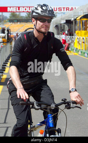 (Dpa) - kommt britischer Formel-1-Fahrer David Coulthard (Red Bull Racing) mit seinem Fahrrad auf der Grand Prix Rennstrecke im Albert Park in Melbourne, Australien, 2. März 2005. Der erste Grand Prix der Saison 2005 startet am 6. März 2005. Stockfoto