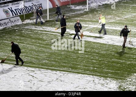 (Dpa) - klare Helfer die Tonhöhe, die im Schnee vor dem deutschen Bundesliga-Spiel zwischen Arminia Bielefeld und Bayern München am SchücoArena in Bielefeld, Deutschland, 13. Februar 2005 bedeckt war. Der Start des Spiels musste um 5 Minuten verzögert werden. Bielefeld 3: 1 gewonnen. Stockfoto