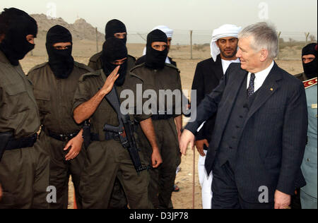 (Dpa) - grüßt German Interior Minister Otto Schily (R) irakische Polizisten, die ihre Gesichter unter Ski-Masken in der Polizei-Schulungszentrum in Al Ain, Vereinigte Arabische Emirate (VAE), 14. Februar 2005 versteckt haben. Seit März 2004 hat die deutsche Polizei irakische Polizisten am Standort unterwiesen. Schily ist bei einem dreitägigen Besuch der persischen Golfstaaten. Stockfoto