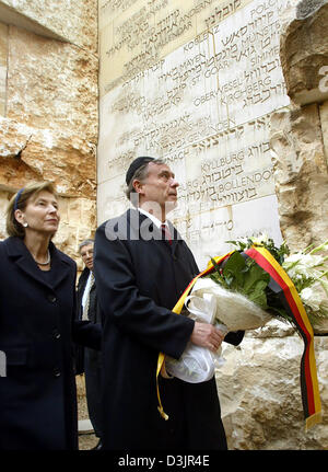 (Dpa) - Bundespräsident Horst Köhler hält Blumen während des Gehens zusammen mit seiner Frau Eva durch das Tal der Gemeinden in der Gedenkstätte Jad Vaschem in Jerusalem, Israel, Dienstag, 1. Februar 2005. Köhler ist auf einen vier-Tages-Besuch in Israel. Stockfoto