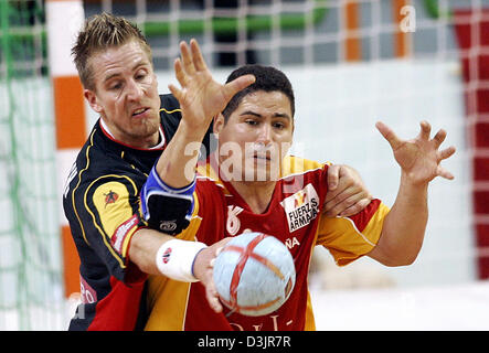 (Dpa) - deutsche Nationalspieler Oliver Roggisch (L) verteidigt gegen Rolando Urios aus Spanien, während die beiden Teams Runde Hauptspiel bei Team Handball-WM der Männer in Nabeul, Tunesien, Montag, 31. Januar 2005. Stockfoto