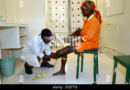 (Dpa) - eine Bein-Prothese ist ausgestattet, um eine ältere Frau, die Opfer von Landminen in der orthopädischen Abteilung des Krankenhauses in der zerstörten Stadt Kuito, Angola, etwa zwei Stunden mit dem Flugzeug aus der Hauptstadt Luanda war. Foto aufgenommen am 3. September 2003. In die zehn Jahren bis ein Waffenstillstand erreicht war schwere Kämpfe in und um Kuito getötet rund ein Drittel der 500.000 inhabita Stockfoto