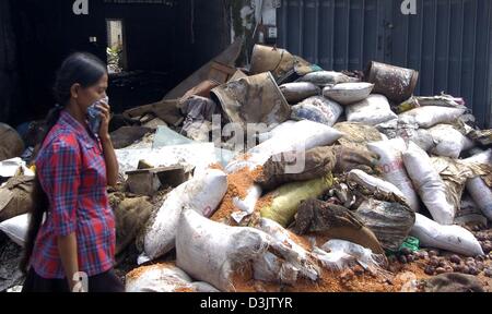 (Dpa) - umfasst eine Frau ihr Gesicht mit einem Tuch um sich vor den Gestank der verwesenden Leichen in der Stadt Dellewatha in der Nähe der Stadt Galle, Sri Lanka, 2. Januar 2005 zu schützen. Hunderttausende von Menschen, die in den Küstengebieten von Sri Lanka, die ihre Häuser verloren und von einem verheerenden Tsunami verursacht durch das Seebeben am 26. Dezember 2004 wurden rund 30.000 Menschen getötet. Stockfoto