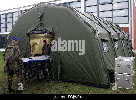 (Dpa) - zwei Sanitäter der deutschen Bundeswehr tragen eine Bahre in einen neuen aufblasbaren Krankenrevier Zelt bei der Friesland-Kaserne in Varel, Deutschland, 3. Januar 2005. Diese Art von Zelt ist auch in diesen Bereichen eingesetzt, die von der Tsunami-Katastrophe in Indonesien getroffen wurden. Die paramedizinischen Assitance für den Einsatz in den Krisenregionen stammen aus der deutschen Armee schnelle Bereitstellung med Stockfoto