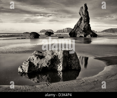 Ebbe und Sonnenuntergang mit vulkanischen Felsen am Strand von Bandon stapeln. Oregon Stockfoto