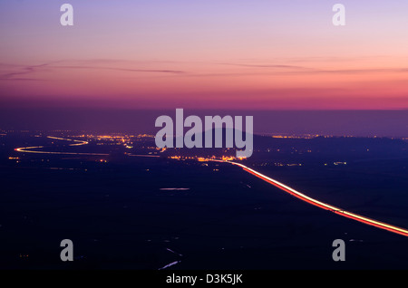 Brent Knoll und der Autobahn M5 von Mendip Hills in der Abenddämmerung, Somerset, England gesehen. Stockfoto