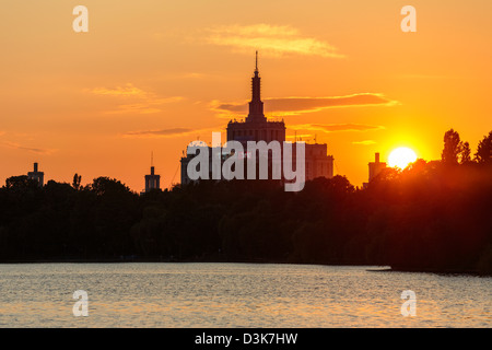 Sonnenuntergang über Haus der freien Presse. Blick von der See im Herastrau Park, Bukarest, Rumänien. Stockfoto