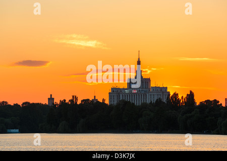 Sonnenuntergang über Haus der freien Presse. Blick von der See im Herastrau Park, Bukarest, Rumänien. Stockfoto