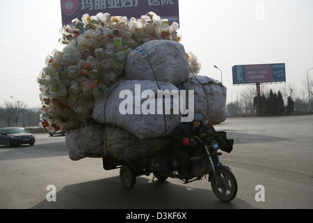 Ein motor Dreirad beladen mit recyclebaren Kunststoff-Flaschen Laufwerke entlang einer Straße in einer Stadt in der Provinz Hebei, China. 17. Februar 2013 Stockfoto