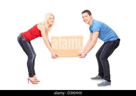 Voller Länge Porträt eines jungen Paares, die versuchen, heben Sie eine Box auf weißen Hintergrund isoliert Stockfoto