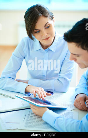 Bild der Geschäftsfrau zeigt etwas zu ihrem Partner auf touchpad Stockfoto