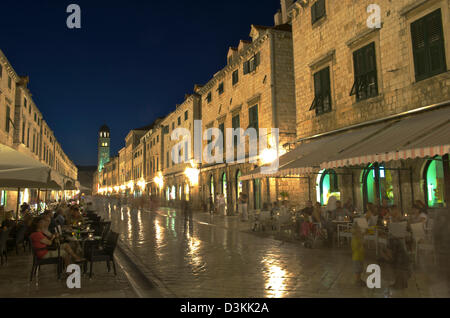 Stradun, die Hauptstraße der Altstadt von Dubrovnik in Kroatien, am späten Abend. Touristen selbst in Cafés genießen. Stockfoto