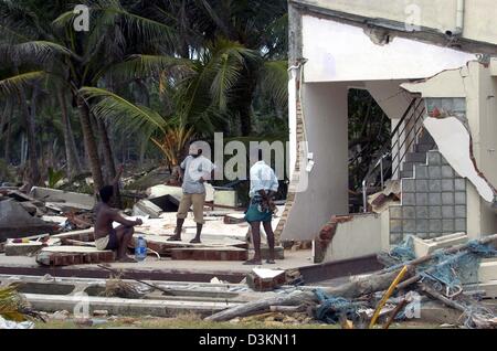 (Dpa) - drei Männer stehen auf den Resten eines Hauses im Dorf Dellewatha, in der Nähe der Stadt Galle, Sri Lanka, 2. Januar 2005. Hunderttausende von Menschen, die in den Küstengebieten von Sri Lanka, die ihre Häuser verloren und von einem verheerenden Tsunami verursacht durch ein Seebeben am 26. Dezember 2004 wurden rund 30.000 Menschen getötet. Stockfoto