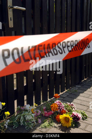 (Dpa) - liegen Blumen vor dem Tor zu den Räumlichkeiten, wo die Leichen von neun Neugeborenen jahrelang in Blumentöpfe und Blumenkästen in Brieskow-Finkenheerd südlich von Frankfurt Oder, Deutschland, Dienstag, 2. August 2005 versteckt worden waren. Eine 39-jährige Frau soll die Leichen von ihren Babys auf dem Gelände begraben haben, nachdem sie direkt nach der Geburt zu töten. Hatten die Babys bleibt Stockfoto