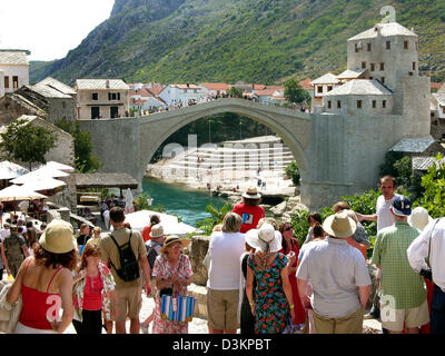 (Dpa) - das Bild zeigt Touristen beobachten die Stari Most Brücke über den Fluss Neretva in der Stadt von Mostar, Bosnien und Herzegowina, 4. September 2004. Die Brücke wurde im Jahr 1993 während des Krieges zwischen Kroatien und Bosnien und Herzegowina zerstört. Die Brücke wurde mit Hilfe internationaler Spendengelder rekonstruiert. Die offizielle Wiedereröffnung Zeremonie fand im Juli 2004. Sinc Stockfoto