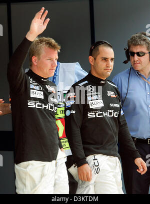 (Dpa) - kolumbianischer Formel1-Fahrer Juan Pablo Montoya (R) und seinem finnischen Teamkollegen Kimi Räikkönen (L) von McLaren Mercedes stehen gemeinsam nach der Qualifying-Session auf der Formel1 Rennstrecke in Monza, Italien, Samstag, 3. September 2005. Räikkönen fuhr die schnellste Zeit vor Montoya Montoya nimmt jedoch die Pole Position, da sich Räikkönen seinen Motor geändert und damit Stockfoto