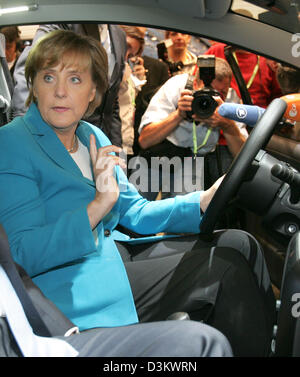 (Dpa) - umgeben von Fotografen Angela Merkel (vorne), Top-Kandidat für den deutschen Kanzlerschaft von der Christlich Demokratischen Union (CDU), sitzt in einem Volkswagen (VW) Fox während ihrer Tour durch den 61. Internationalen Automobilausstellung (IAA) in Frankfurt Main, Deutschland, Samstag, 17. September 2005. Die IAA öffnete seine Pforten für die Öffentlichkeit am selben Tag. Foto: Uli Deck Stockfoto