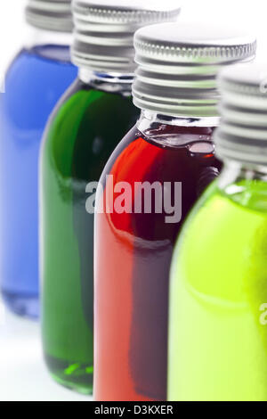 Flaschen in einer Reihe mit verschiedenen farbigen Flüssigkeit Stockfoto