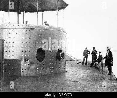 Undatierte Foto zeigt die USS Monitor Deck ich freue mich auf der Steuerbordseite, während das Schiff im James River in Virginia, 9. Juli 1862 war. Der Turm mit der Schnauze eines Monitors zwei 11-Zoll-Dahlgren langläufige Waffen zeigen, ist auf der linken Seite. Beachten Sie Dellen in Turmpanzerung von Treffern von konföderierten Geschütze und Besatzungsmitgliedern oben auf dem Turm. Offiziere (von links nach rechts): dritte Assistant Engineer Robinson W. Hände, Schauspiel Master Louis N. Stodder, Second Assistant Ingenieur Albert B. Campbell (sitzend) und handeln freiwillig Lieutenant William Flye (mit dem Fernglas). Stockfoto