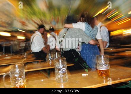 (Dpa) - sitzen spät Oktoberfest Besucher auf Tabellen nach der Schließung der ein Bierzelt Oktoberfest in München, späten Sonntag, 2. Oktober 2005. Mindestens 6,1 Millionen Besucher waren in diesem Jahr zum größten Volksfest der Welt. Bezüglich des Veranstalters berichten über Montag, 3. Oktober 2005, 6 Millionen Liter Bier wurden verkauft, das ist ein Minus von fünf Prozent zum Vorjahr, und Stockfoto