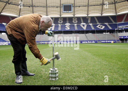 (Dpa) - Engelbert Lehmacher inspiziert den Rasen auf die AOL Arena in Hamburg, Deutschland, Dienstag, 25. Oktober 2005. Lehmacher ist Mitglied des sogenannten "Grass Expertenteams", um sicherzustellen, dass die besten möglich Rasen Rasen in deutschen Fußballstadien, die als Host Stellplätze, die FIFA WM 2006-Spiele verantwortlich. Foto: Ulrich Perrey Stockfoto