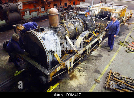 (Dpa) - Mitarbeiter des Werks Dampfmaschine Meiningen untersuchen die ausgebrannte Modell der legendären Adler Dampfmaschine in Meiningen, Deutschland, Mittwoch, 9. November 2005. Am 18. September 2005 wurde der Motor in den verheerenden Brand im Eisenbahnmuseum in Nürnberg beschädigt. Laut der Deutschen Bahn (DB) sind die Prerequisits für den Wiederaufbau des Adler-Motor gut, seit t Stockfoto