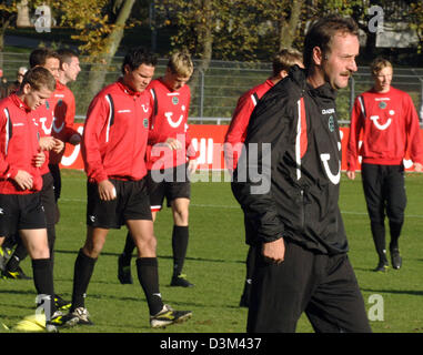 (Dpa) - Deutsche Bundesliga Fußballverein Hannover 96 neue Trainer Peter Neururer (vorne) lächelt leicht während seiner ersten Trainingseinheit mit der Mannschaft in Hannover, Donnerstag, 10. November 2005. 50-Jahre-alten Neururer Vertrag überraschend einen bis 2007 am Vortag. Neururer wurde bereits vor 11 Jahren Hannovers Trainer. Foto: Wolfgang Weihs Stockfoto