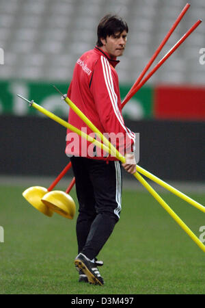 (Dpa) - Deutschlands Assistamt Trainer Joachim Loew vertreibt rote und gelbe gefärbte Stangen auf dem Spielfeld während einer Übung von der deutschen Fußball-Mannschaft in Paris, Frankreich, Freitag, 11. November 2005. Deutschland bereitet sich auf das internationale Testspiel gegen Frankreich im Stade de France in Paris auf Samstag, 12. November 2005. Foto Bernd Weissbrod Stockfoto