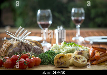 Gebratenes Lammkarree mit gebratenem Gemüse, Zwiebeln, Karotten, Tomaten, Brokkoli und Kartoffelpüree Stockfoto