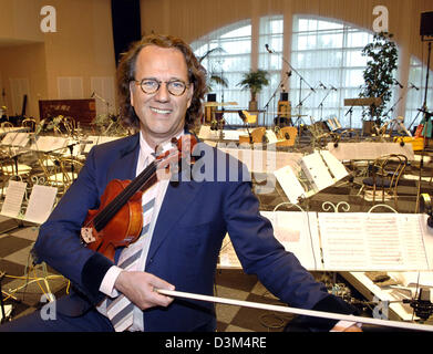 (Dpa) - niederländische Stargeiger André Rieu hält eine Geige stehend in seinem Atelier in Maastricht, Niederlande, 2. November 2005. Der 56 Jahre alte Musiker ist kurz vor dem start des ersten Teil seiner Tour durch Kanada und die USA, wo er in 13 Großstädten durchführen wird. Die komplette Ausrüstung seiner Crew, die 40 Personen zu zahlen, war schon in Container verladen und Versand Stockfoto