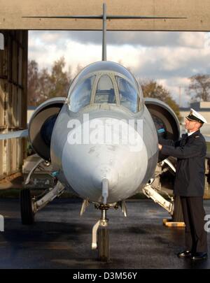 (Dpa) - ein Seemann sieht ein Starfighter F-104 G-Jet auf dem Gelände der Marinebasis in Kiel-Holtenau, Deutschland, 21. November 2005. Die entmilitarisierte Jet, der einst in Eggebek stationiert werden, über das Internet angeboten werden soll und versteigert von der VEBEG GmbH, eine Treuhandgesellschaft für die Bundesrepublik Deutschland in Frankfurt am Main, Deutschland. Foto: Wulf Pfeiffer Stockfoto