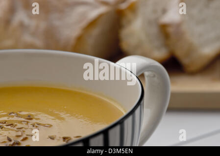 Retro-Stil Becher voll von Kürbissuppe mit geröstetem Kreuzkümmelsamen an der Spitze Stockfoto