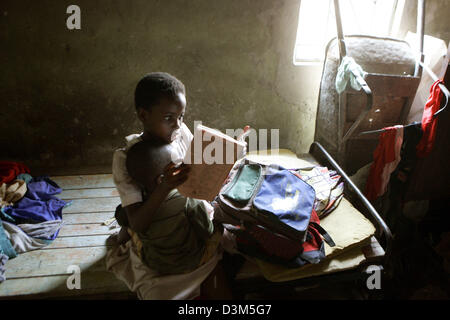 (Dpa) - das Bild zeigt Sarah mit ihrem jüngeren Bruder auf dem Arm, während sie ihre Hausaufgaben in Lukasa, Sambia, 28. September 2005 tut. Die Bevölkerung von Sambia umfasst 90 verschiedene ethnische Gruppen. Sambia gehört zu den Ländern der Welt die Aids-Epidemie am schwersten betroffen. Foto: Jens Kalaene Stockfoto