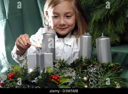 (Dpa) - erster Sonntag im Advent: Sarah leuchtet die erste Kerze der festlich dekorierten Adventskranz, Düsseldorf, 24. November 2005. Vorbereitung für Weihnachten beginnt mit dem Beginn der Adventszeit. Foto: Achim Scheidemann Stockfoto