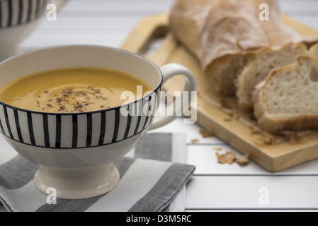 Retro-Stil Becher voll von Kürbissuppe mit geröstetem Kreuzkümmelsamen an der Spitze Stockfoto