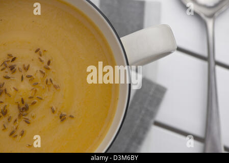 Retro-Stil Becher voll von Kürbissuppe mit geröstetem Kreuzkümmelsamen an der Spitze Stockfoto