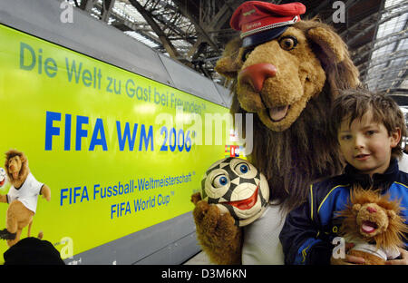 (Dpa) - FIFA-Maskottchen Goleo VI (L) und einen jungen stehen neben einer offiziellen FIFA World Cup 2006-Zug am Hauptbahnhof in Leipzig, Deutschland, Mittwoch, 7. Dezember 2005. Die Deutsch Bahn AG (DB) ist einer der sechs nationalen Förderer der WM in Deutschland und präsentiert den Motor mit den Logos von der FIFA WM 2006 in Leipzig zusammen mit Goleo heute, Freitag. Der Motor, der th Stockfoto