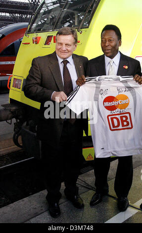 (Dpa) - brasilianische Fußball-Legende Pele (R) und Hartmut Mehdorn, Vorstandsvorsitzender der Deutschen Bahn AG (DB), präsentieren einen signierten Fußball-Trikot, wie sie vor einer Lokomotive am Hauptbahnhof in Leipzig, Deutschland, Samstag, 10. Dezember 2005 stehen. Die DB ist eine von insgesamt sechs deutschen Sponsoren der Fußball-WM 2006. Foto: Michael Hanschke Stockfoto