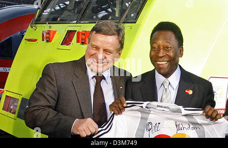 (Dpa) - brasilianische Fußball-Legende Pele (R) und Hartmut Mehdorn, Vorstandsvorsitzender der Deutschen Bahn AG (DB), präsentieren einen signierten Fußball-Trikot, wie sie vor einer Lokomotive am Hauptbahnhof in Leipzig, Deutschland, Samstag, 10. Dezember 2005 stehen. Die DB ist eine von insgesamt sechs deutschen Sponsoren der Fußball-WM 2006. Foto: Michael Hanschke Stockfoto