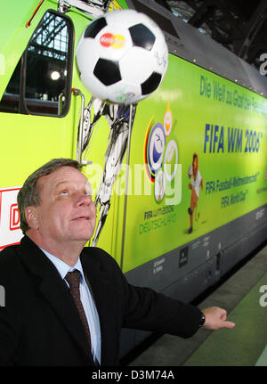 (Dpa) - Hartmut Mehdorn, Vorstandsvorsitzender der Deutschen Bahn AG (DB), jongliert mit einem Fußball als He Stand vor der eine Lokomotive, mit der WM-Logos am Hauptbahnhof in Leipzig, Deutschland, Samstag, 10. Dezember 2005. Die DB ist eine von insgesamt sechs deutschen Sponsoren der Fußball-WM 2006. Foto: Michael Hanschke Stockfoto