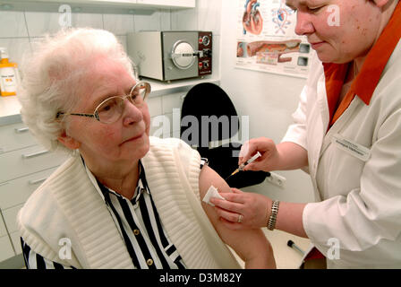 (Dpa) Datei - Empfangsdame spritzt einen ältere Dame Impfstoff bei einem praktizierenden interne Allgemeinchirurgie, Iserlohn-Hennen, Deutschland, 7. Juli 2004. Foto: Klaus Rose Stockfoto