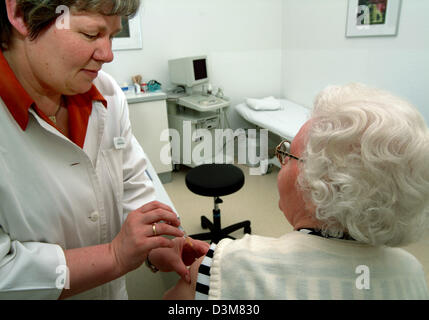 (Dpa) Datei - Empfangsdame spritzt einen ältere Dame Impfstoff bei einem praktizierenden interne Allgemeinchirurgie, Iserlohn-Hennen, Deutschland, 7. Juli 2004. Foto: Klaus Rose Stockfoto