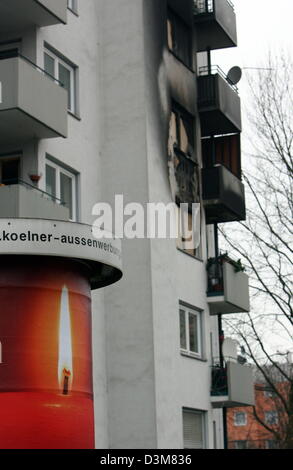 (Dpa) - eine Anzeige mit einer Kerze kann man auf eine Litfasssäule vor eine siebengeschossige Wohnhaus in Köln-Mülheim, Deutschland, 24. Dezember 2005. Fünf Menschen, darunter zwei kleine Brüder starben bei einem Brand in diesem Haus Anfang 24 Dezember. Sechs weitere wurden bei dem Brand verletzt. Vier der getöteten Personen gehören zu einer Großfamilie aus Angola, nach po Stockfoto