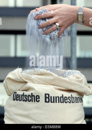 (Dpa) - ein Mitarbeiter der Deutschen Bundesbank ("Bundesbank") hält geschredderten Geld über eine Tasche in der Zentrale in Frankfurt am Main, 17. November 2005. Alltag in der "Bundesbank" bringt Tränen in den Augen jedes Einlegers. Sechs Mitarbeiter betätigen die Schredder-Maschine bis zu drei Mal pro Woche nach alten zerstören und unbrauchbar Banknoten. Foto: Arne Dedert Stockfoto